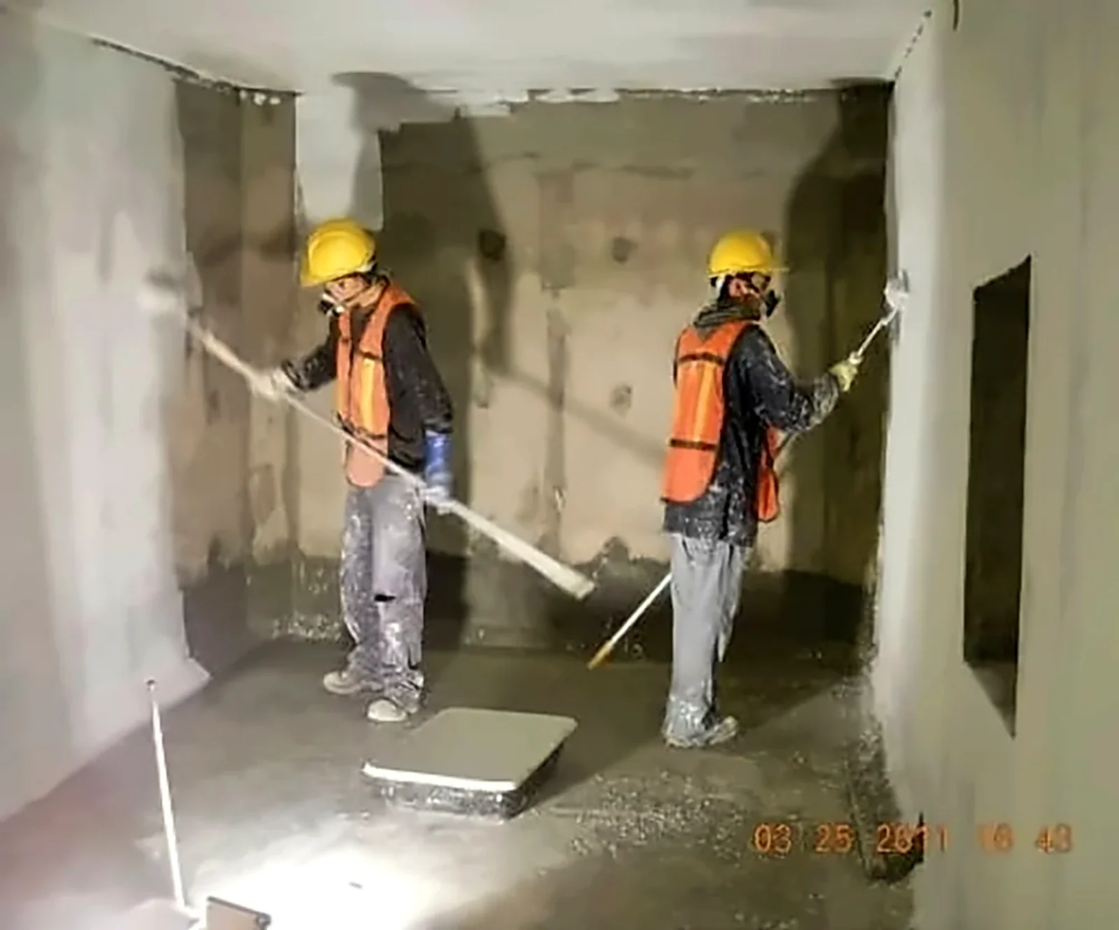 Técnicos aplicando en muros interiores de concreto